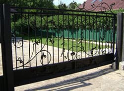Откатные кованые ворота с листом металла черного цвета